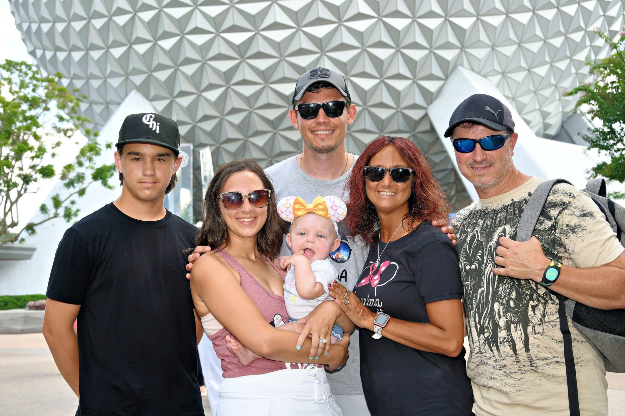 Family of six posing in front of Spaceship Earth at EPCOT