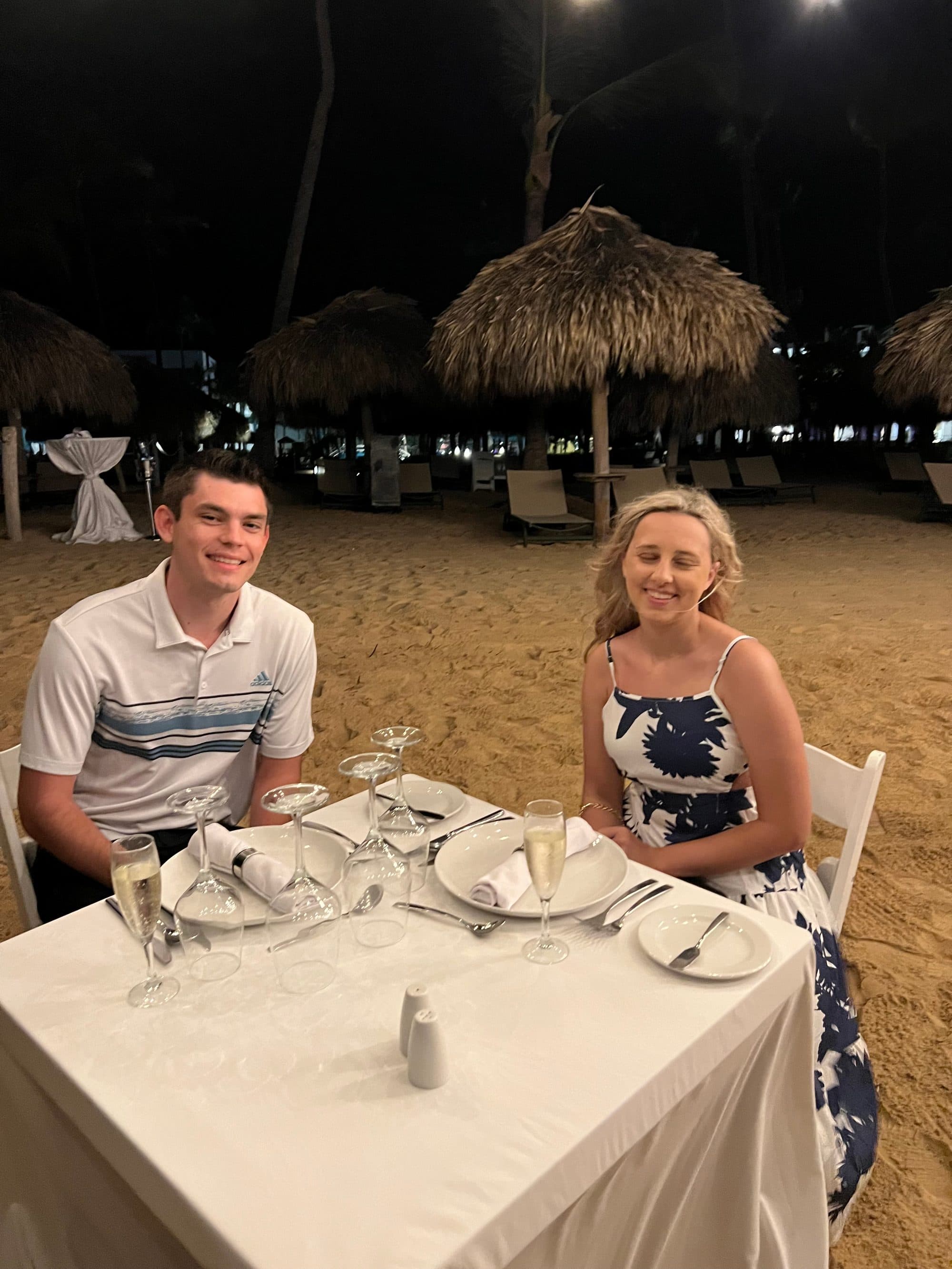 Couple at a private candlelit dinner table set up on the beach
